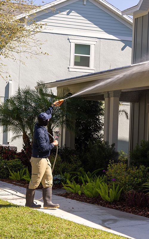 pressure washing professional washing roof of home
