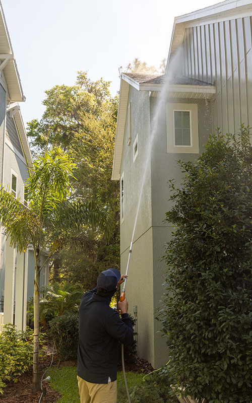 pressure washing professional washer upper siding area of green home